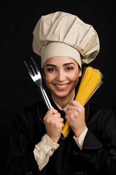 Uśmiechnięty Kucharz Kapeluszem Szefa Kuchni Trzyma Surowe Spaghetti Widelec Rzeźbiarski — Zdjęcie stockowe