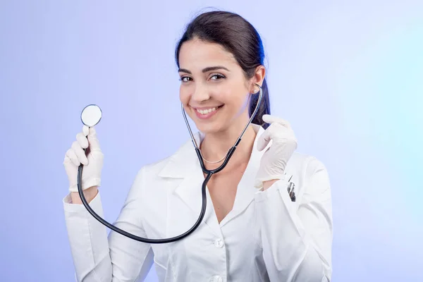 笑顔女性医師でホワイトコートとともにStethoscope上の光の背景 — ストック写真