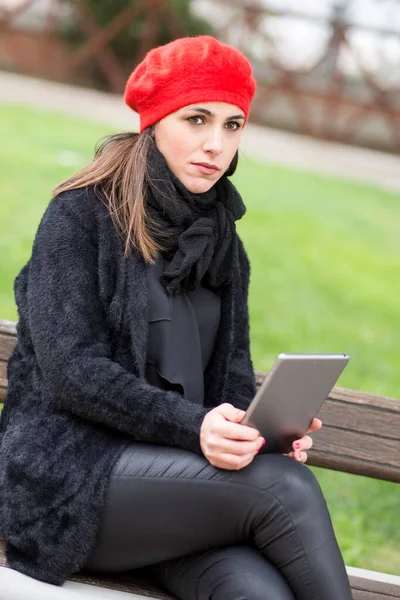Siyah Giyimli Kırmızı Kulaklıklı Bir Kız Parkta Bankta Oturuyor — Stok fotoğraf