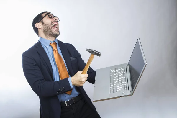 黑发男子留着胡子 身穿衬衫套装 夹克和橙色领带 手里拿着一个带锤子的笔记本电脑 与白色背景隔离 — 图库照片