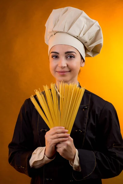 Smiling Cook Chef Hat Holds Raw Spaghetti Hand Which She — Stock Photo, Image