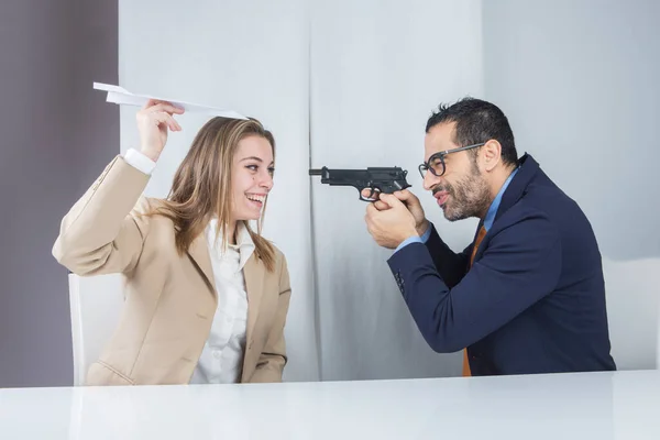 Двое Коллег Сидят Своем Рабочем Месте Менеджер Направляет Пистолет Секретаря — стоковое фото