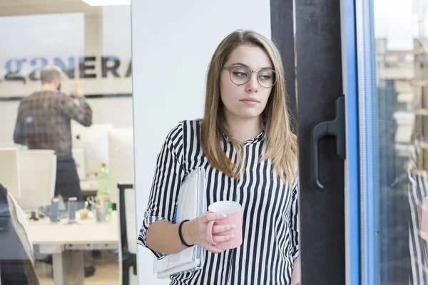 事務所に眼鏡をかけた若い女性とコーヒーのカップの肖像画 ビジネスコンセプト — ストック写真