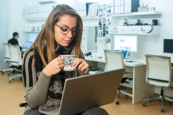 眼鏡をかけたブロンドの女の子とストライプのシャツはオフィスの職場でコンピュータの前に座り — ストック写真