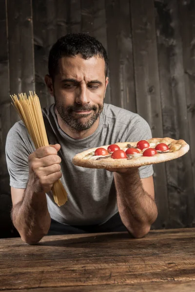 Ciemnowłosy Mężczyzna Brodą Jest Niezdecydowany Czy Jeść Spaghetti Czy Pizzę — Zdjęcie stockowe