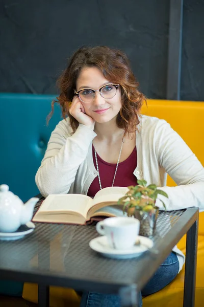 一个漂亮的女孩在咖啡店里 穿着白色毛衣喝茶 — 图库照片