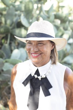 Kıdemli kadın kameraya gülümsüyor.