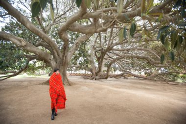 Kırmızı battaniyeye sarılı genç bir kadın.