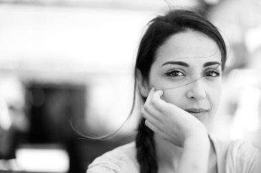 Çevreye dalmış siyah saçlı bir kızın siyah beyaz fotoğrafı.