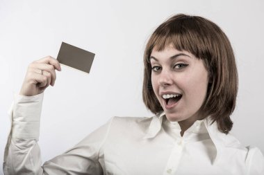 Kısa saçlı kız, beyaz arka planda izole edilmiş bir kart gösteriyor.