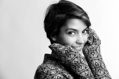 Süveteri olan güzel bir kız, gülüyor, beyaz arka planda soyutlanıyor, siyah ve beyaz