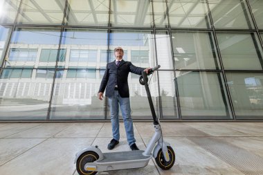 Elektrikli scooterlı takım elbiseli iş adamı