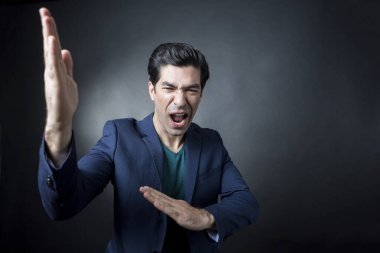 Koyu renk saçlı, yeşil tişörtlü adam koyu arka planda izole edilmiş.