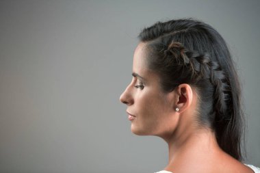 Gri arka planda güzel bir genç kadının portresi