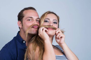 Genç mutlu çift beyaz arka planda öpüşüyor.