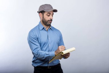 Gri şapkalı teslimatçı gri arka planda izole edilmiş.