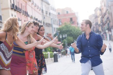 Çocuk araba kullanıyormuş gibi yapıyor ve dört kadın şehirde otostop çekiyor.