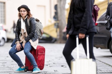 Avrupa 'nın eski caddesinde bavullu iki kadın turist.