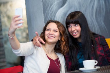 Kafede selfie çeken iki güzel kız.