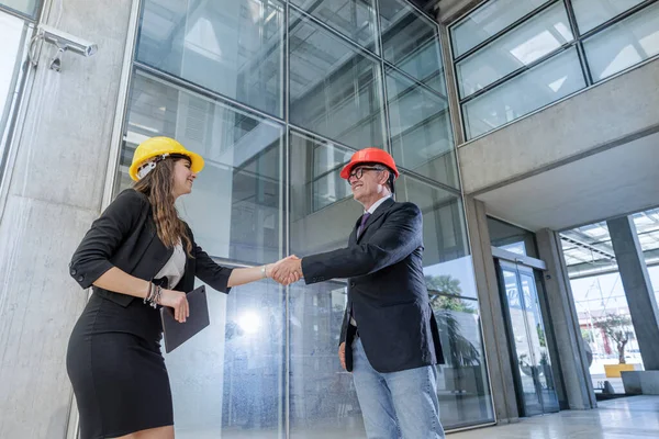 Pair Engineers Protective Helmets Shaking Hands Agreement Context Modern Architecture — Stock Photo, Image