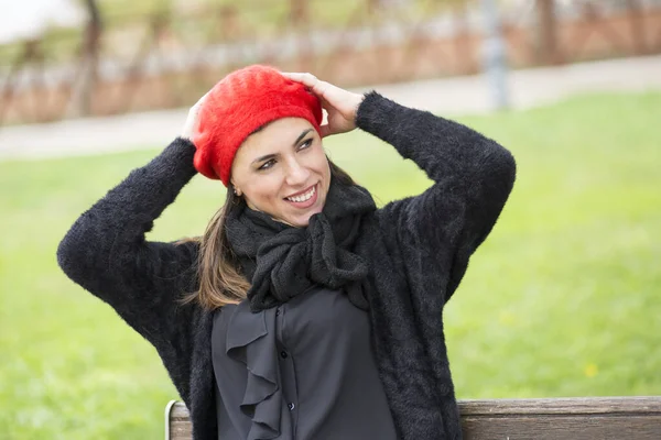 Dziewczyna Ubrana Czarno Czerwonym Zestawem Słuchawkowym Siedzącym Ławce Parku — Zdjęcie stockowe