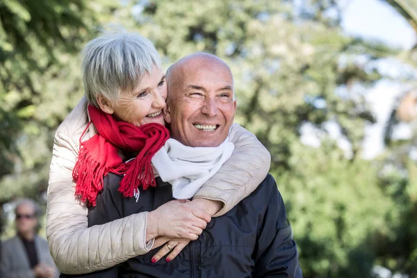 公園で笑顔で抱きかかえてくれる幸せな先輩夫婦 — ストック写真