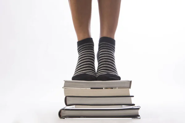 Женские Ноги Стопкой Книг Белом Изолированном Фоне — стоковое фото