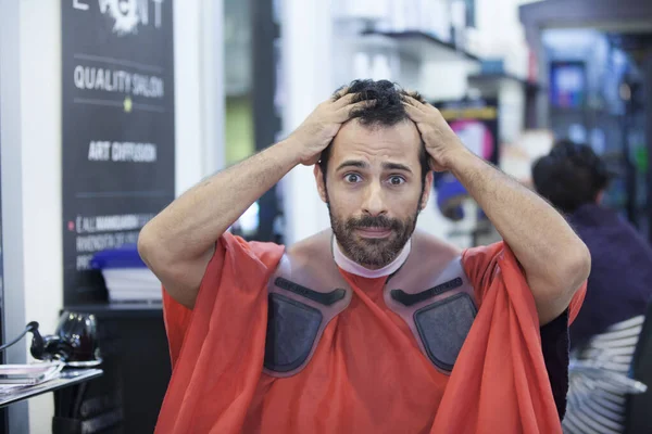 Mężczyzna Patrzy Swoje Włosy Rozpaczliwym Wyrazem Twarzy Gdy Siedzi Fryzjera — Zdjęcie stockowe
