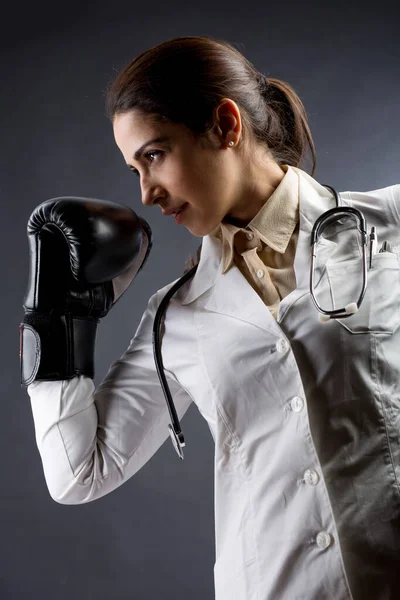 白いコートとボクシングの手袋の女性医師と対決と戦いの準備ができて 白い背景に隔離された — ストック写真
