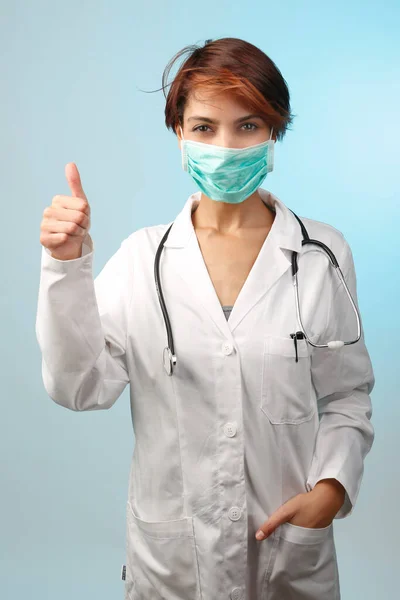带外科口罩 浅蓝色背景隔离的女医生 — 图库照片