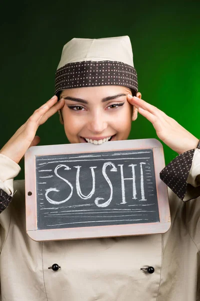 Kucharz Europejski Mundurze Trzyma Tablicę Napisem Sushi Odizolowaną Zielonym Tle — Zdjęcie stockowe