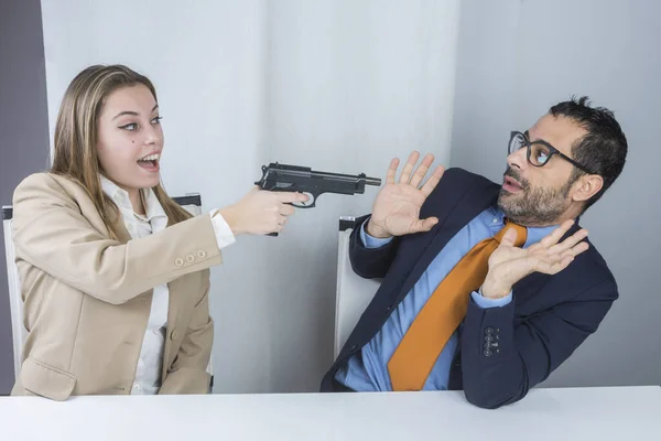 Двое Коллег Сидящих Рабочем Месте Секретарь Шутку Направляет Пистолет Своего — стоковое фото