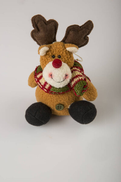 Вертикальное фото милой куклы оленя Санта Клауса на белом фоне