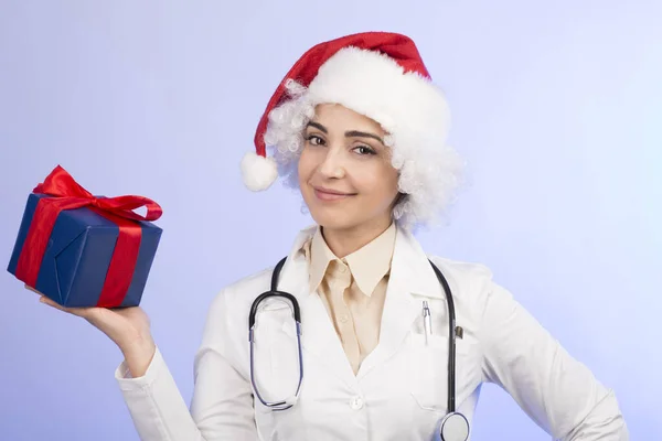 Женщина Врач Белом Халате Шляпе Санта Клауса Держит Подарок Изолированный — стоковое фото
