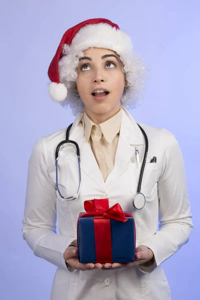 Kvinna Läkare Vit Rock Och Santa Claus Hatt Håller Gåva — Stockfoto