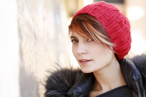 光の背景に赤い帽子をかぶったとてもかわいい女の子の肖像画 — ストック写真
