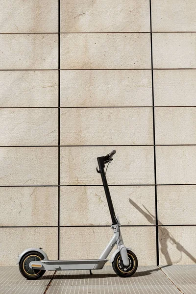 Elektroroller Geparkt Vor Einer Weißen Wand Mit Rechteckigen Fliesen — Stockfoto