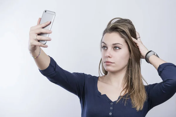 Blondynka Dziewczyna Niebieskiej Koszuli Robi Selfie Smartfonem Odizolowany Białym Tle — Zdjęcie stockowe