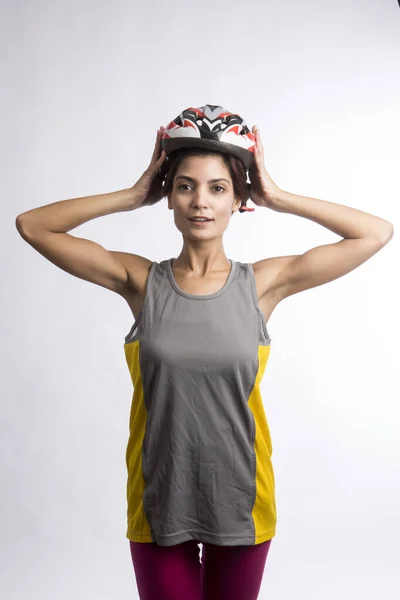 技術的なヘルメットの女性サイクリストは光の背景に隔離され — ストック写真