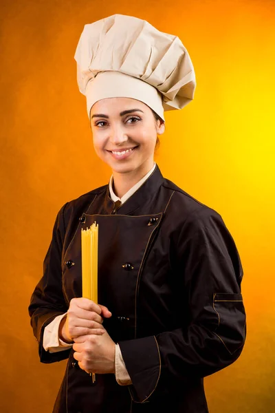 Cocinera Sonriente Con Sombrero Chef Sostiene Espaguetis Crudos Mano Que — Foto de Stock