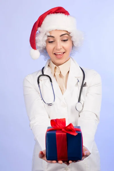 Kobieta Lekarz Białym Płaszczu Santa Claus Kapelusz Posiada Dar Prezencie — Zdjęcie stockowe
