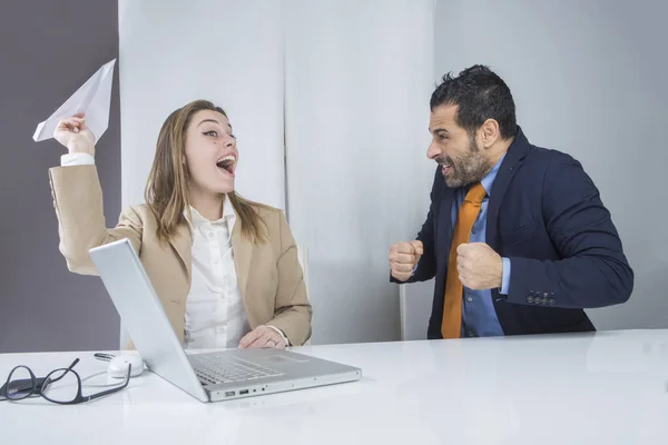 オフィスに座っている女の子は紙飛行機を起動します上司が彼女に対して激怒している間 — ストック写真