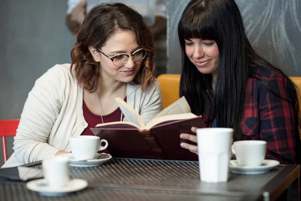 两个年轻女子在咖啡店看杂志 — 图库照片
