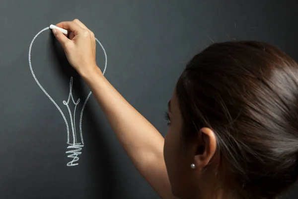 Woman Draws Light Bulb White Chalk Blackboard — Stock Photo, Image