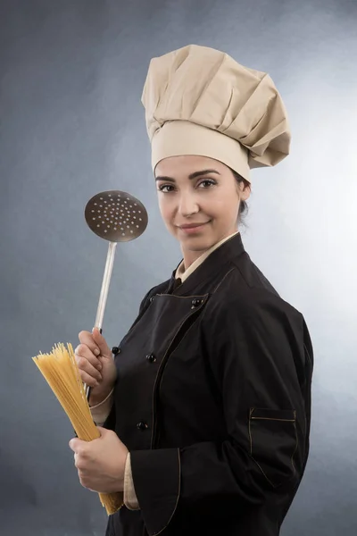 Lächelnder Koch Mit Kochmütze Hält Rohe Spaghetti Und Eine Kelle — Stockfoto
