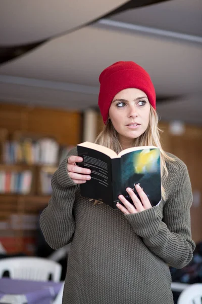Kafasında Kırmızı Bir Şapka Kitaplı Bir Süveter Olan Güzel Sarışın — Stok fotoğraf