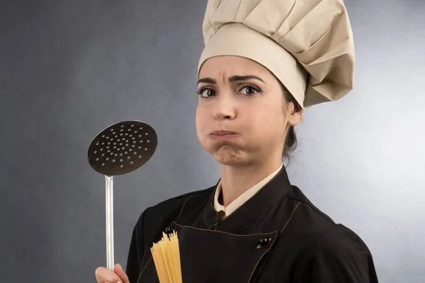 用厨师帽泡着 拿着勺子做饭 用黑色背景隔开 — 图库照片