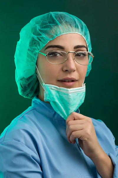 身穿蓝色外套的医生 放下绿色面罩 手握绿色背景隔离的手 — 图库照片