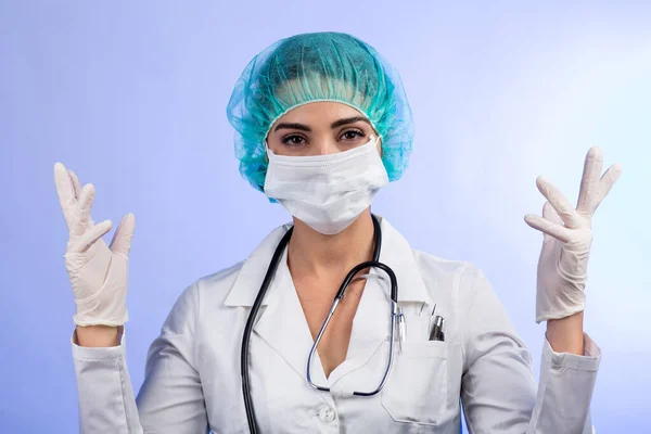 身穿白衣 戴白色面罩 头戴绿色发帽的女医生在手术前戴乳胶手套 在白色背景下隔离 — 图库照片