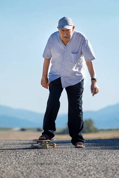 Achtzigjähriger Genießt Skateboarden Auf Landstraße — Stockfoto
